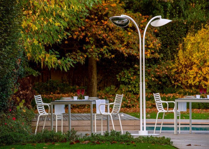 Aménagement terrasse design : terrasse extérieure avec table blanche et chaises assorties sous lampadaire chauffant moderne
