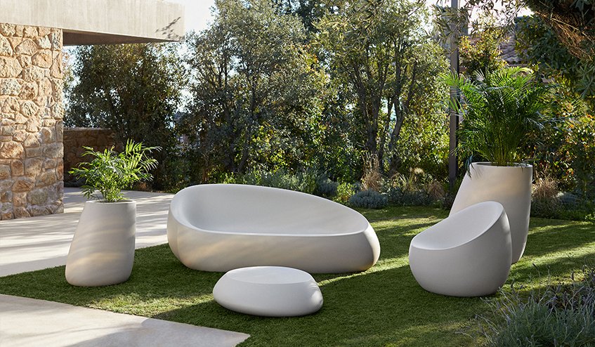 Salon de jardin design blanc, assises ovoïdes et jardinières en extérieur.