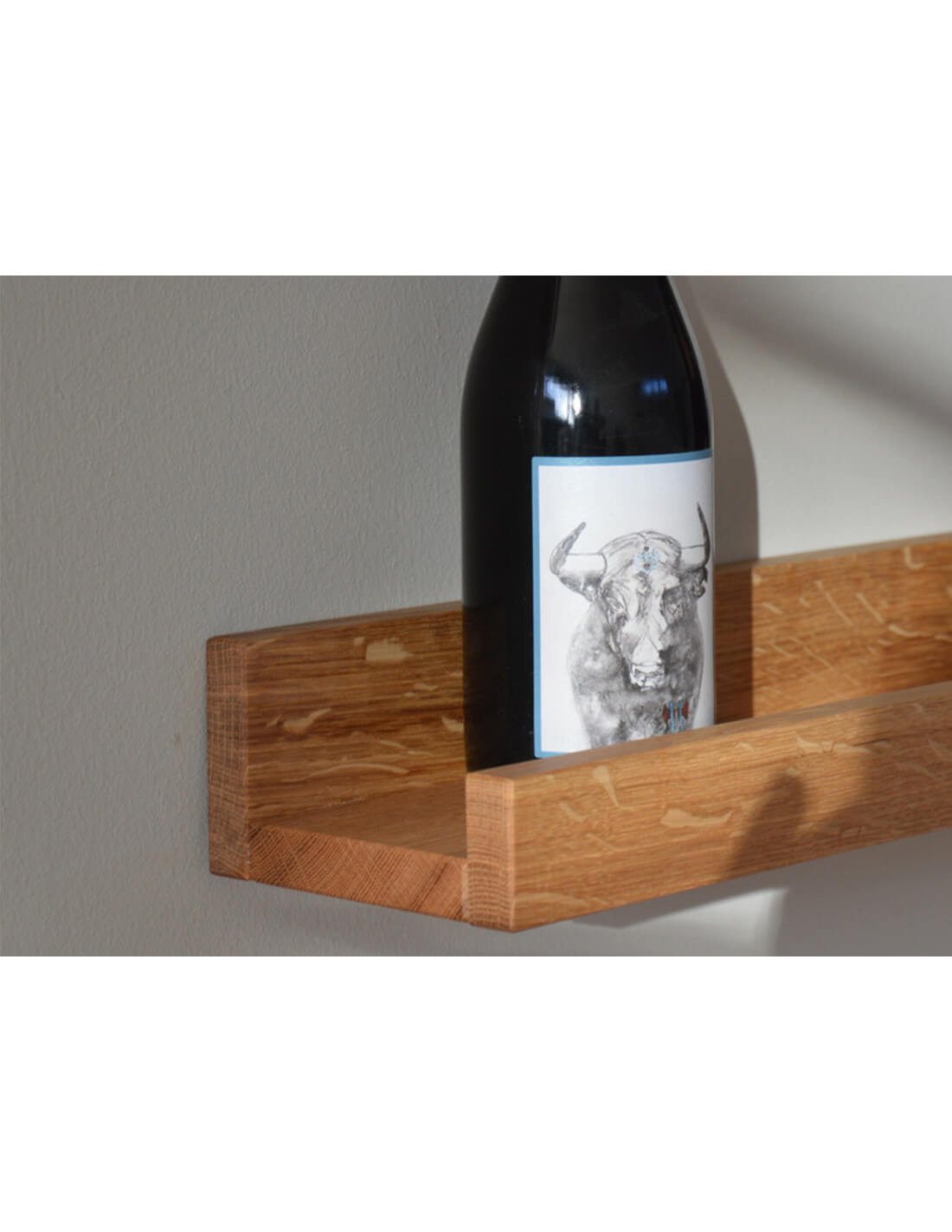 Support mural en bois avec bouteille de vin déposée surélevée, autre mobilier de rangement minimaliste.